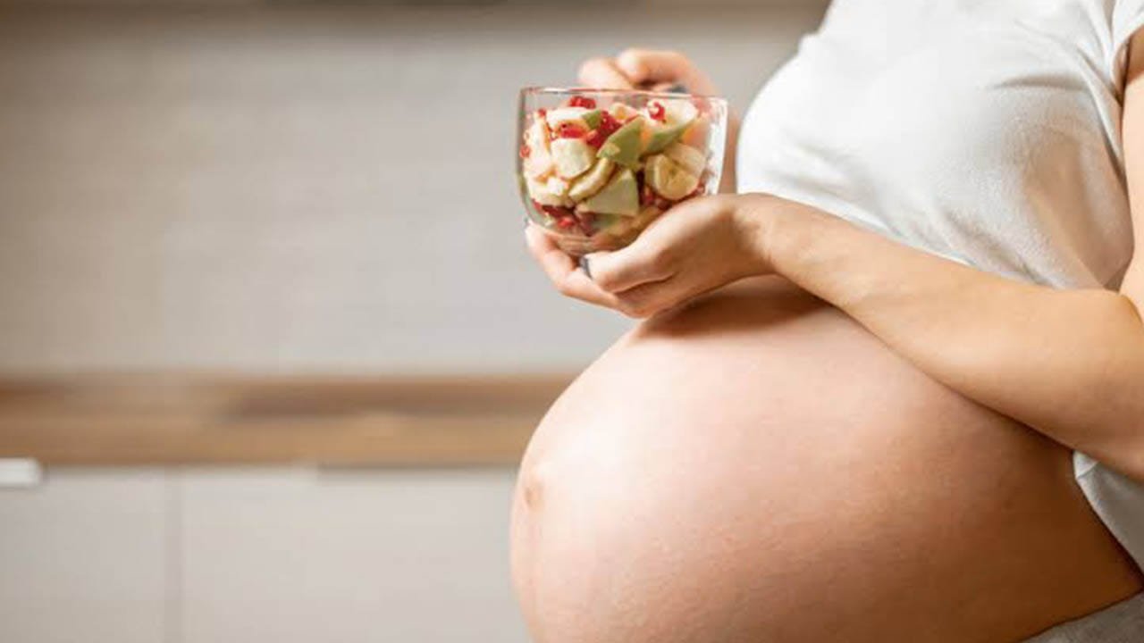 Mulher grávida se alimentando em artigo sobre Placa retrocervical de endometriose